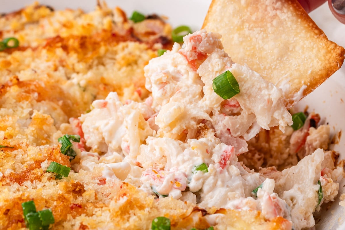 closeup of a chip dipping into hot crab dip