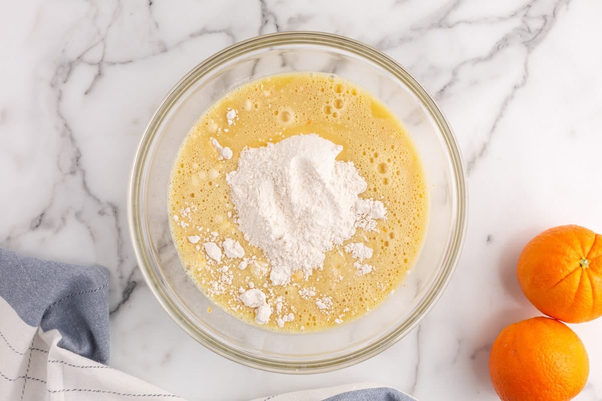 dry ingredients over whipped eggs in a bowl