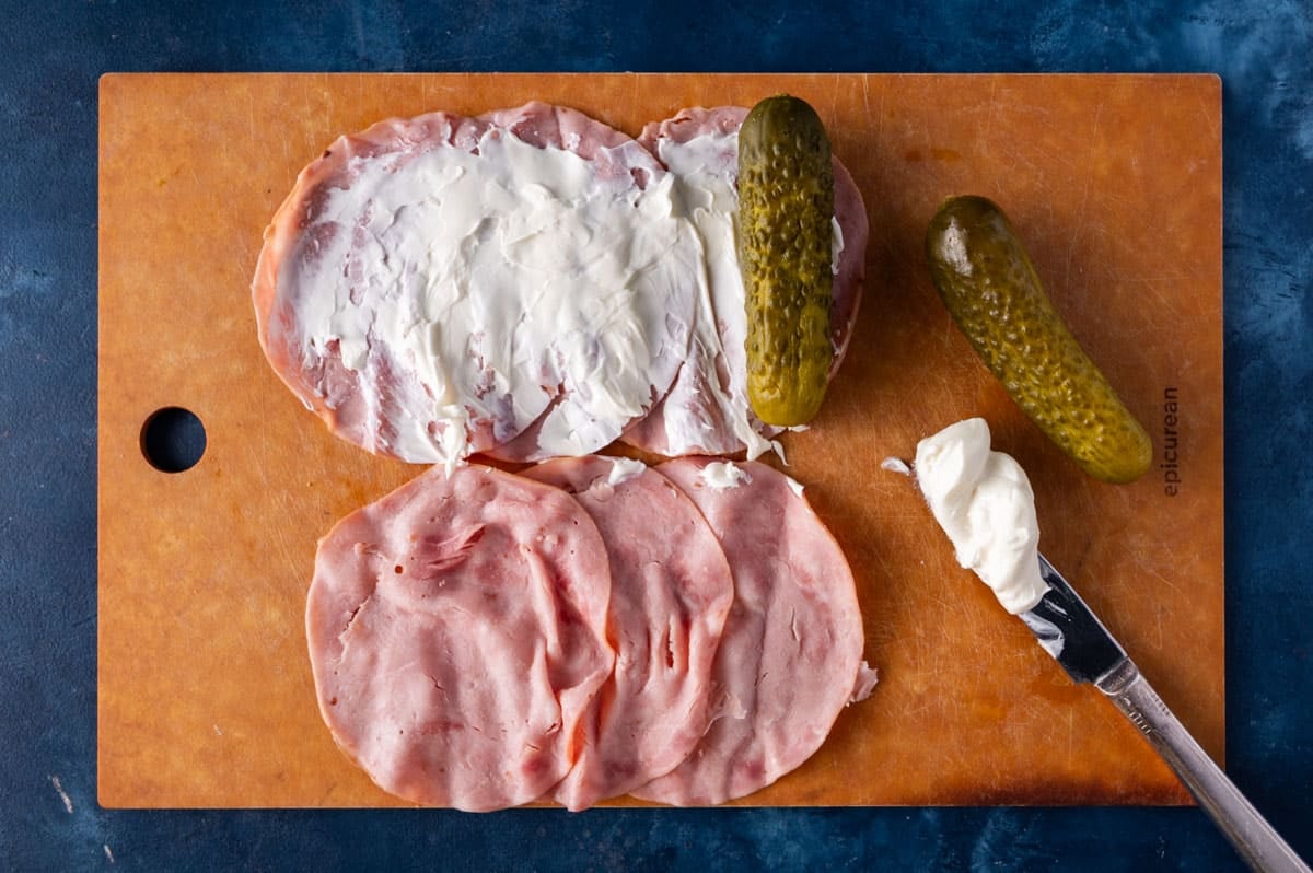 ham, cream cheese and pickles on a table