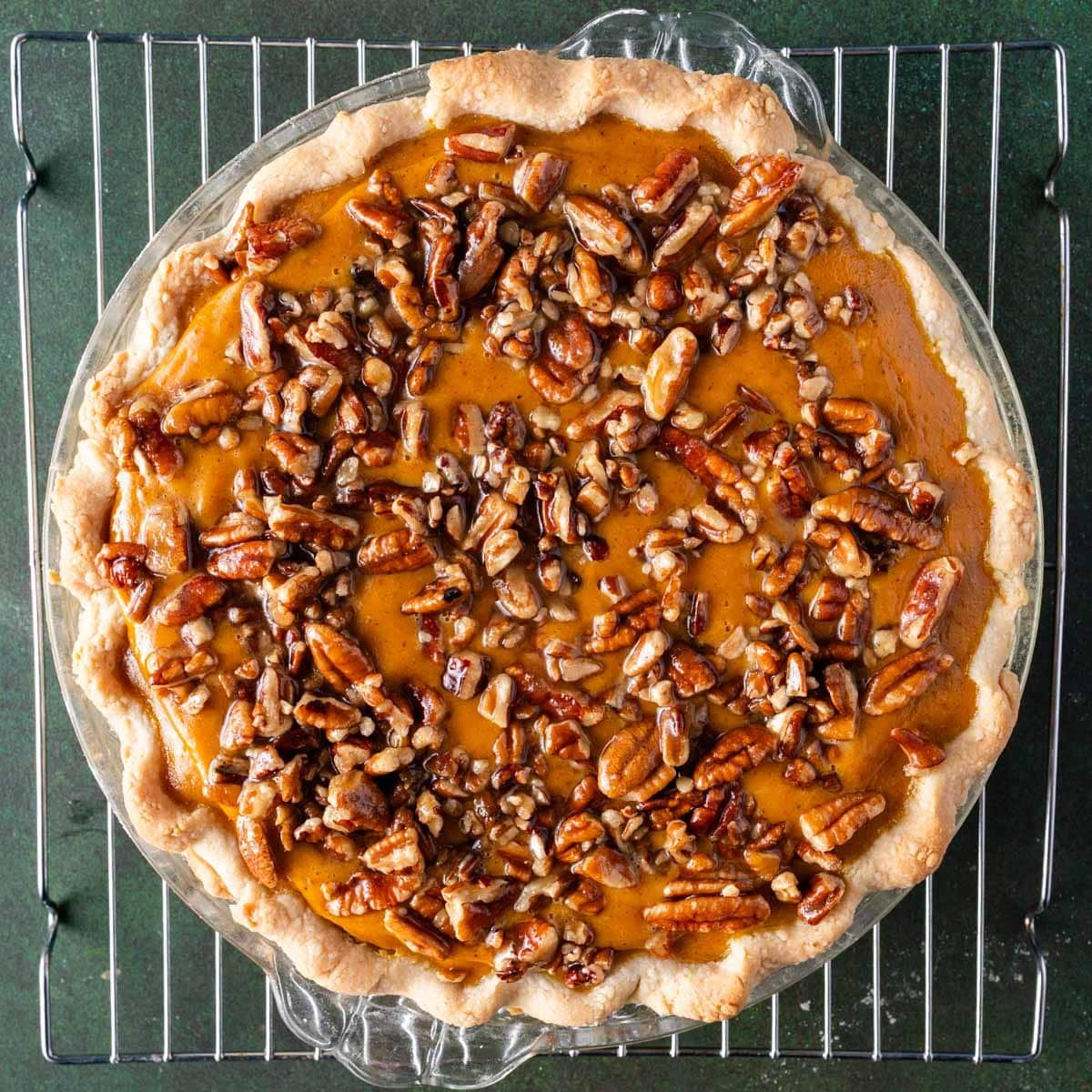 unbaked pumpkin pie with pecans sitting on top