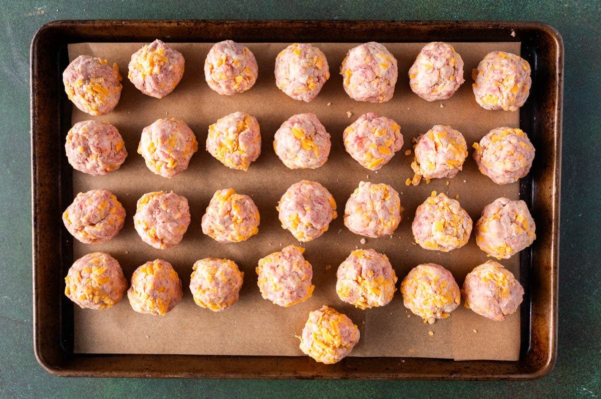 unbaked sausage meatballs on a baking pan