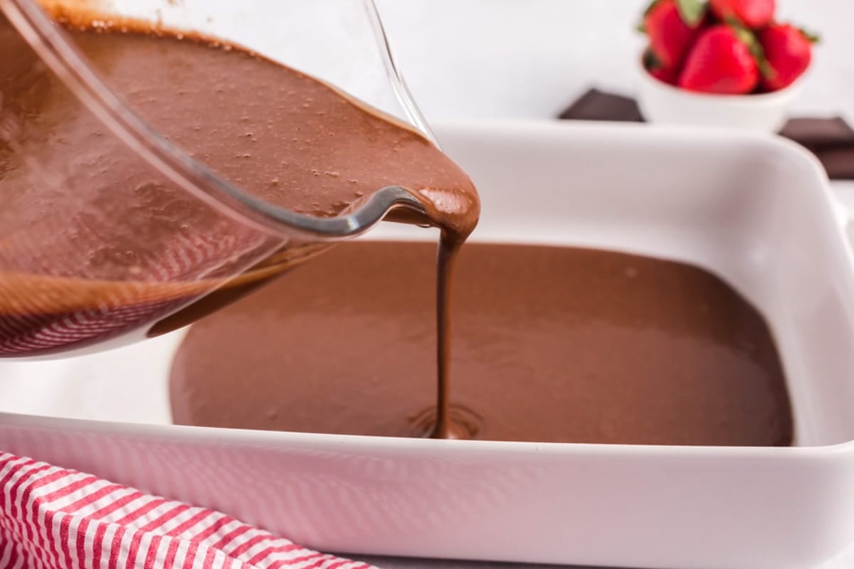pouring cake batter into a bowl
