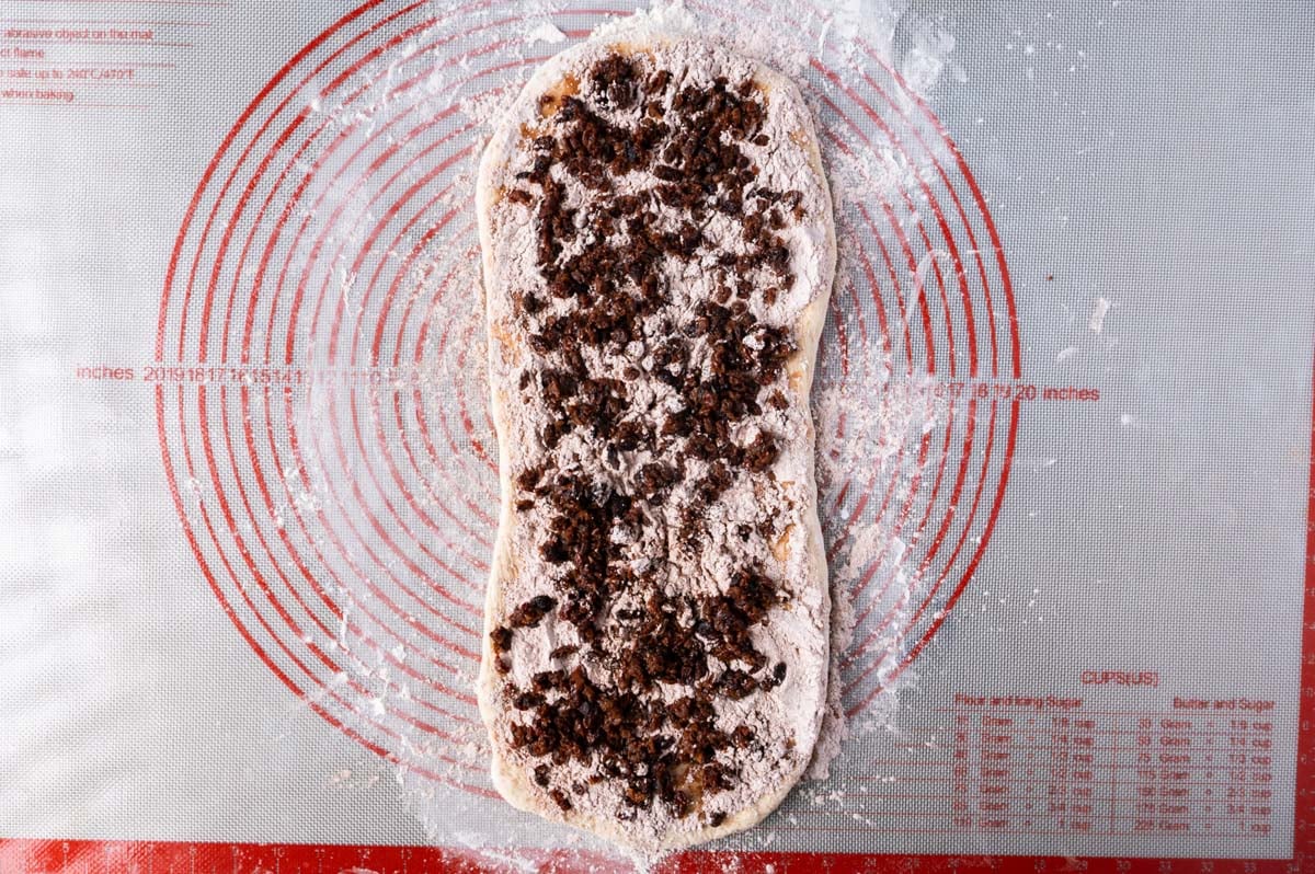 rolled out dough with sugar, cinnamon and raisins