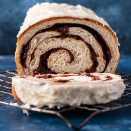 frosted cinnamon bread with raisins on a wire rack