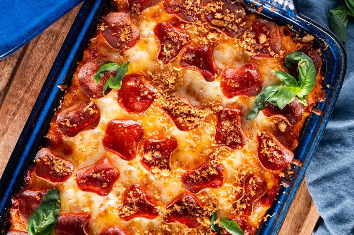 pizza pasta casserole with hot honey and toasted bread crumbs on top