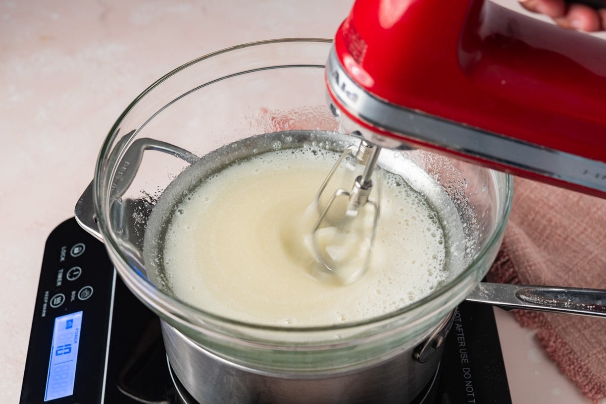 a hand mixer beating egg whites in a bowl