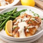 a plate of tilapia with green beans and lemon dijon sauce