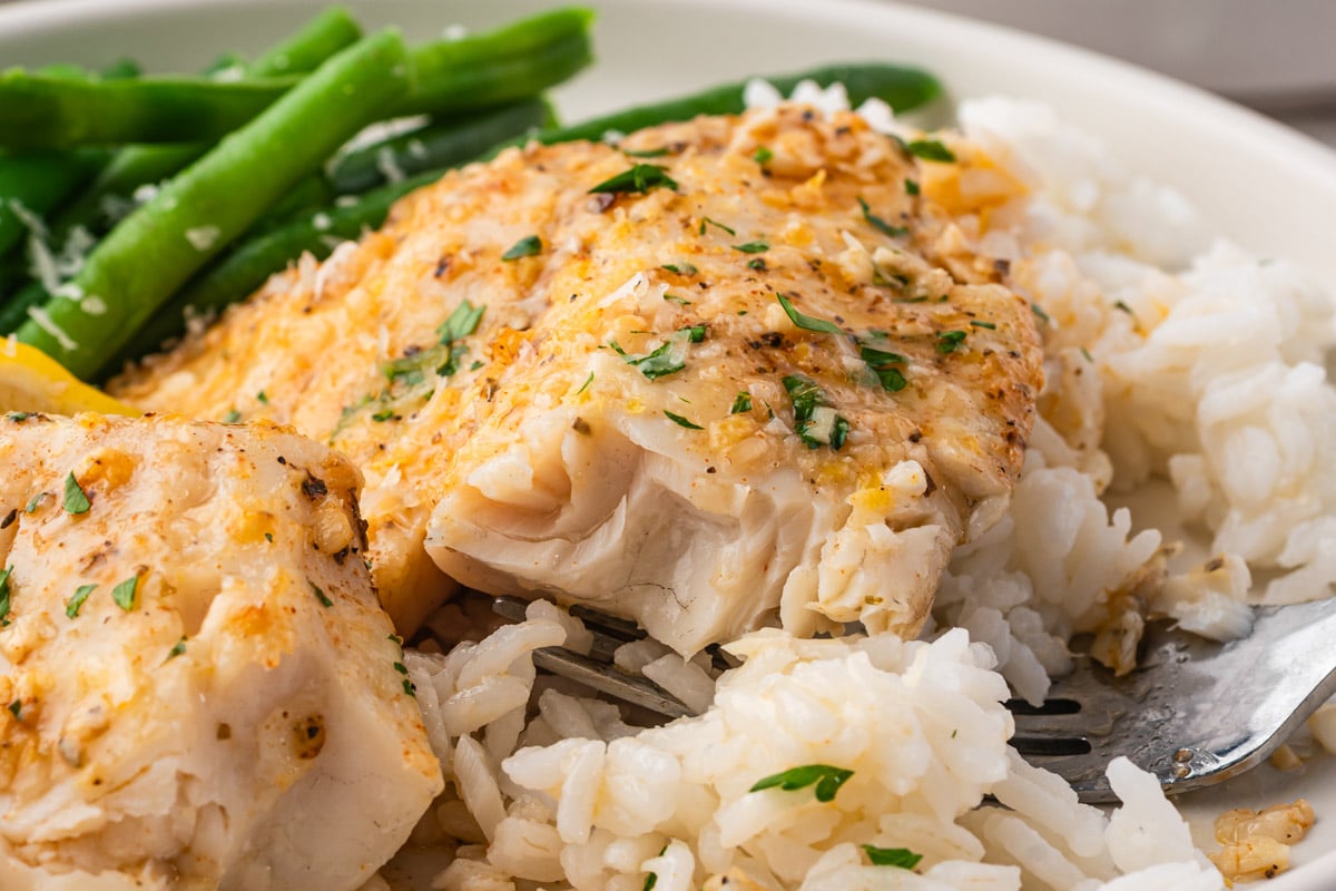 fork tender garlic lemon tilapia on a plate with rice