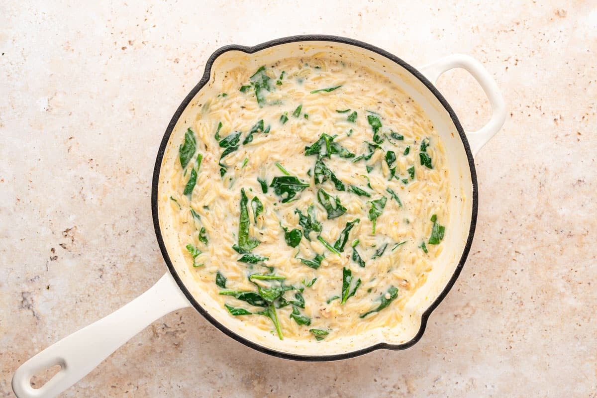 creamy orzo and spinach in a skillet