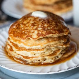 a stack of oatmeal pancakes with butter and syrup