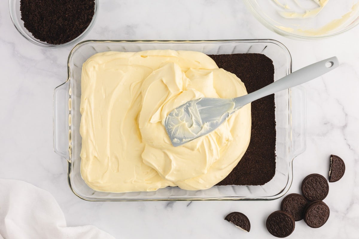 spreading cheesecake filling over oreo crust