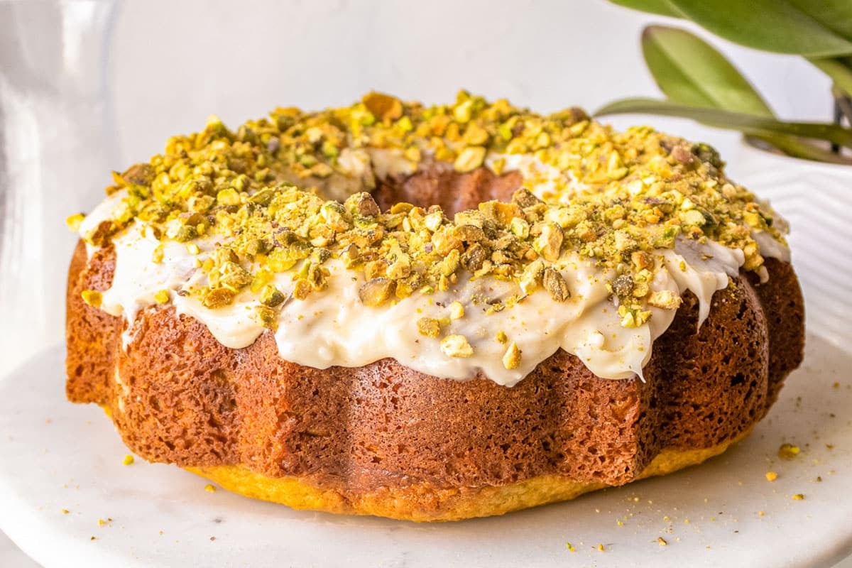 a frosted pistachio cake on a plate