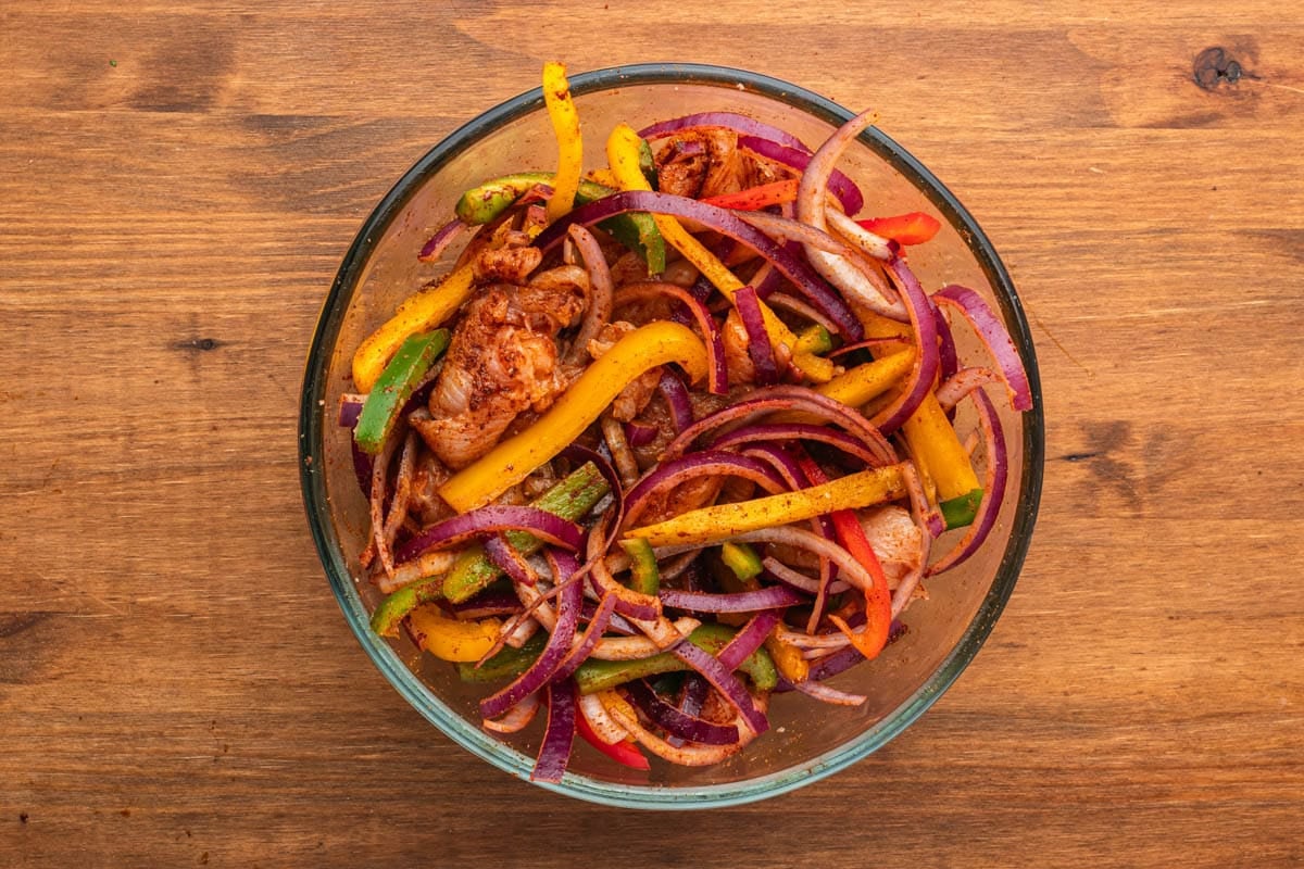 seasoned chicken, peppers and onions in a bowl