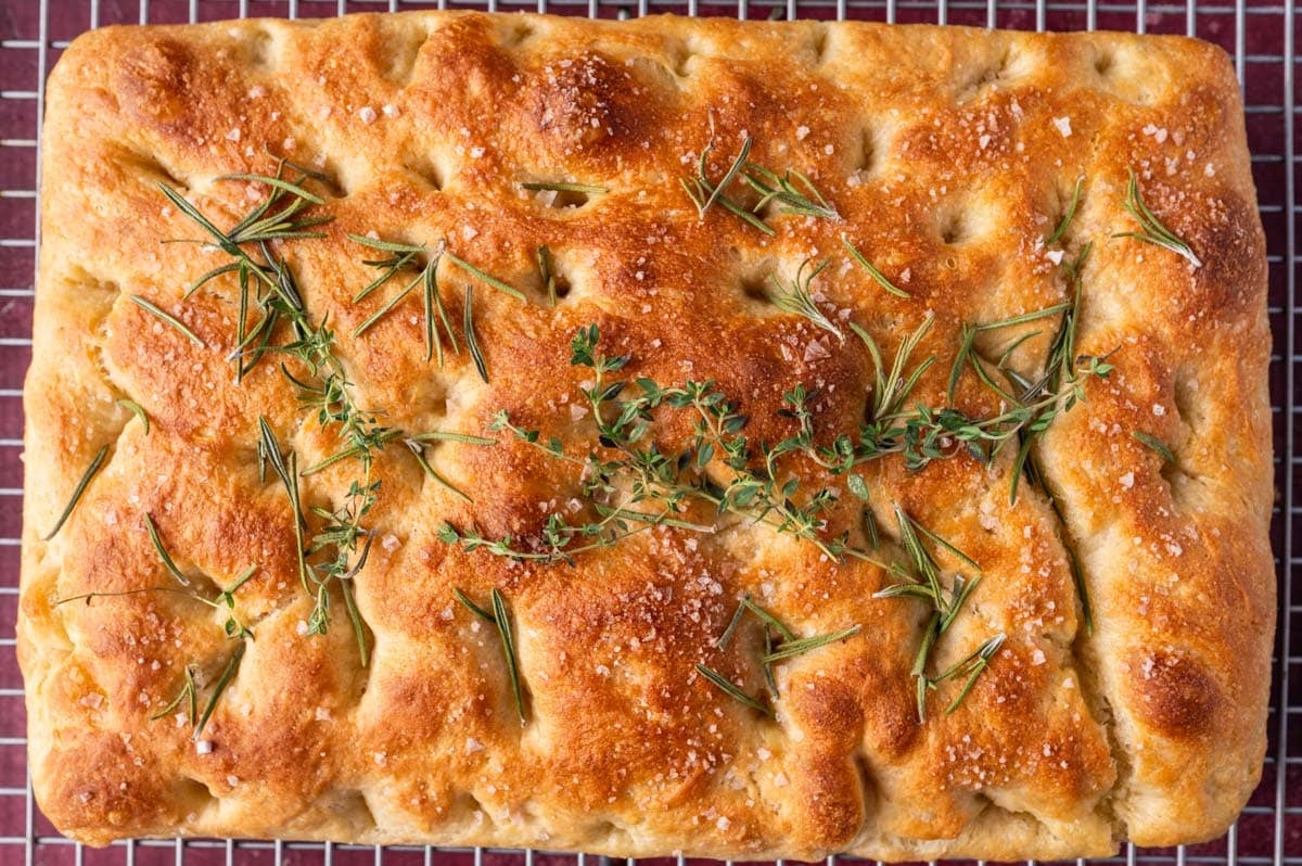 overhead view of focaccia with fresh herbs on top
