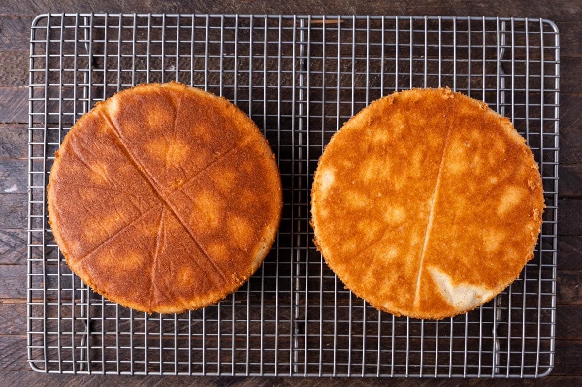 two baked white cakes on a wire rack