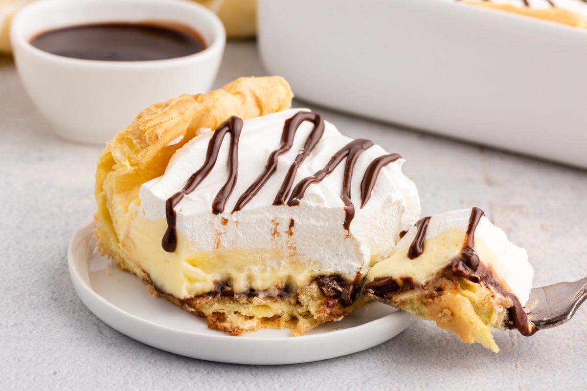 a fork with a bite out of cream puff dessert
