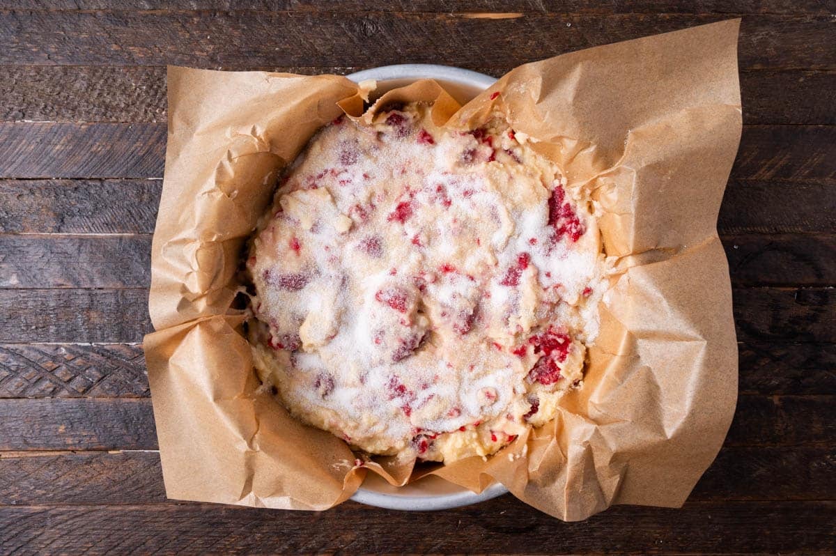 unbaked cake with raspberries on a table