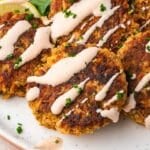 a pile of salmon patties with mayo sauce on a plate