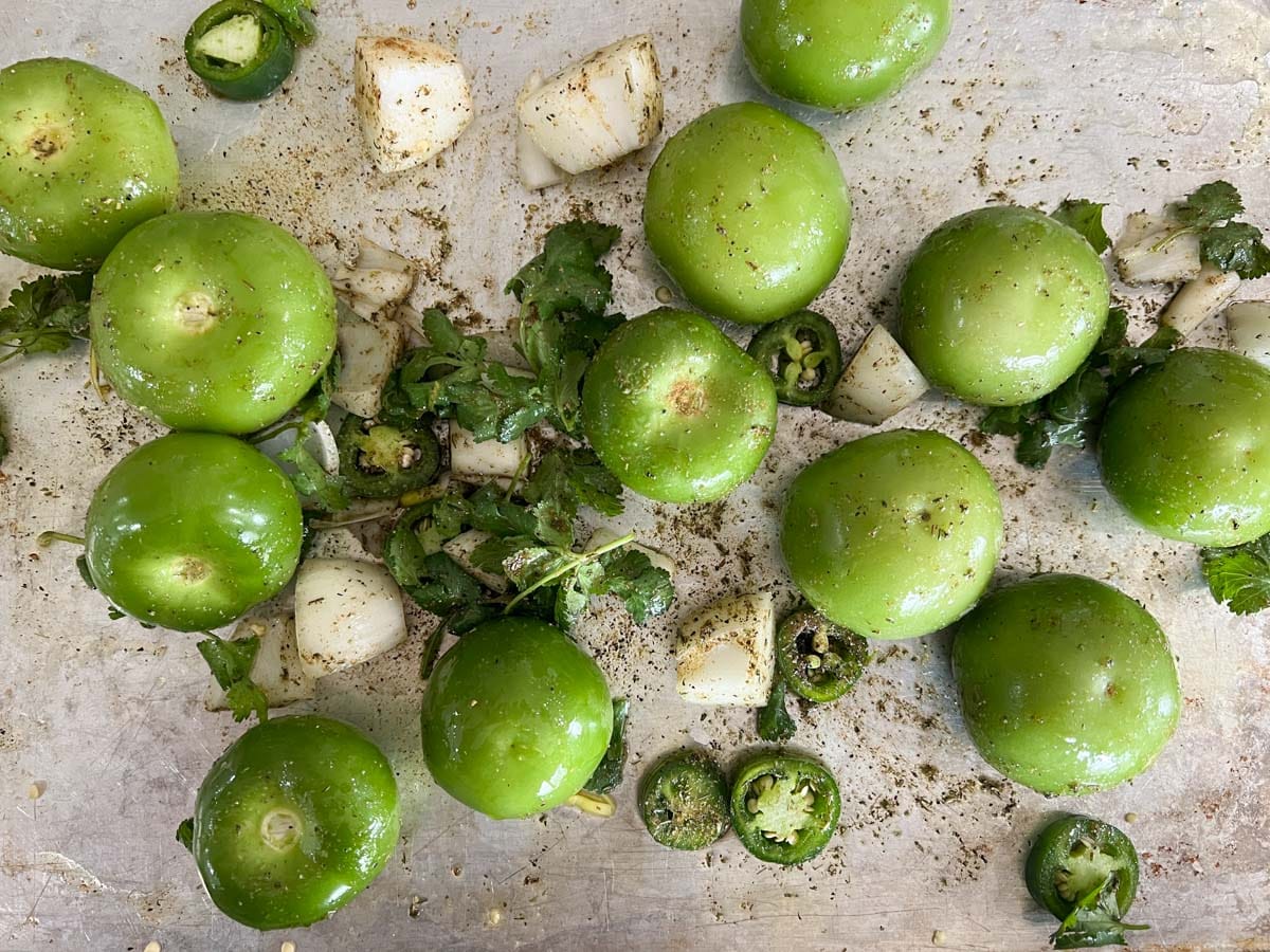 tomatillos, onions and jalapenos on a roasting pan