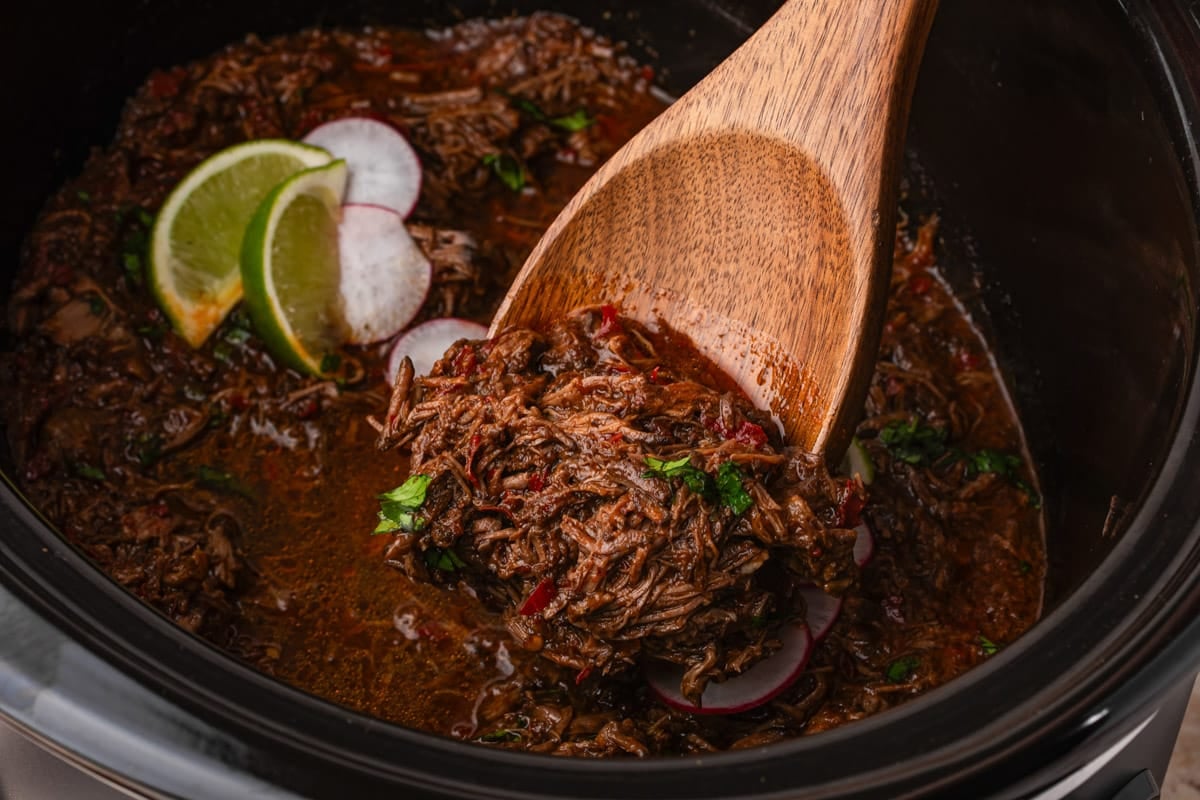 a wooden spoon with shredded mexican beef