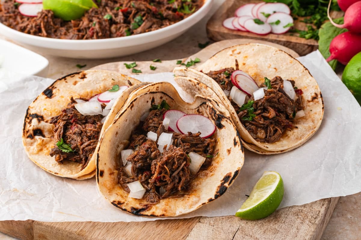 3 beef barbacoa tacos on a table