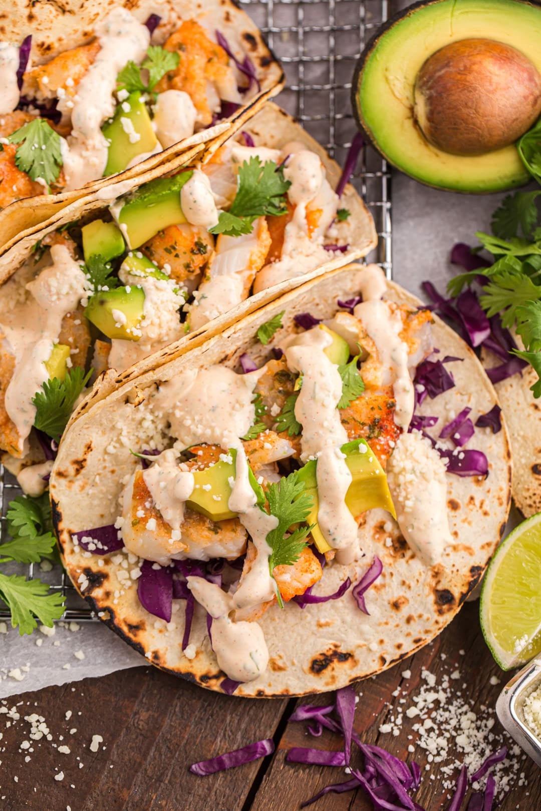 3 cod tacos with toppings on a table
