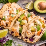 3 baja fish tacos with sauce on a table