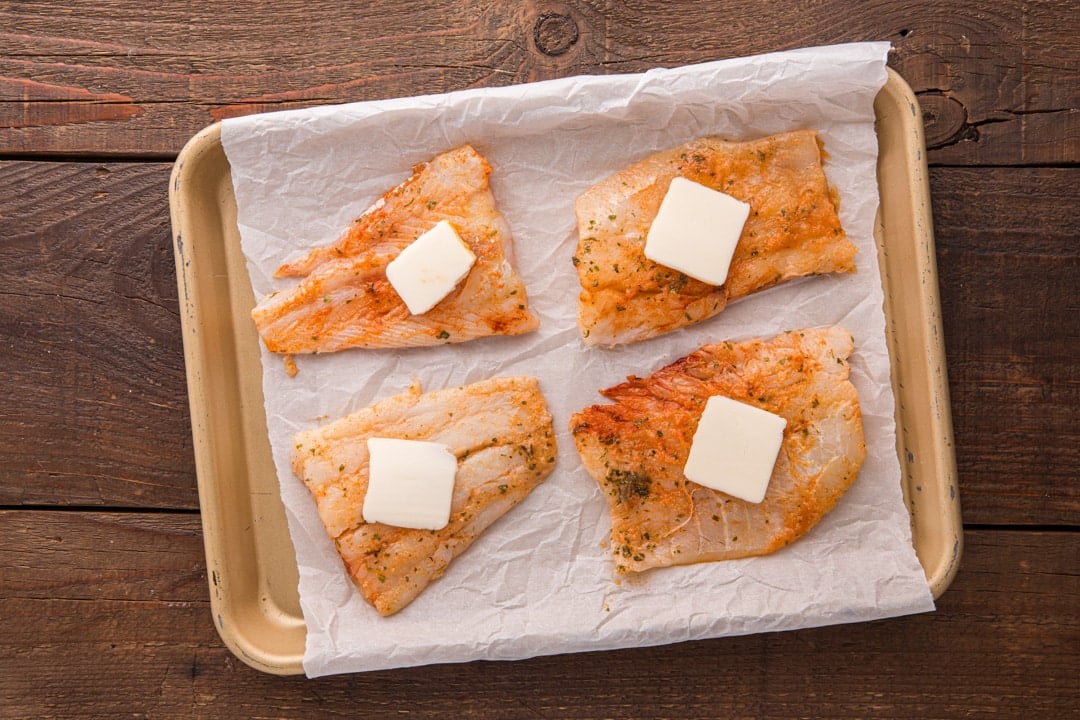 cod fillets on a pan with butter on top