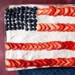 closeup of a flag sheet cake with strawberries and blueberries