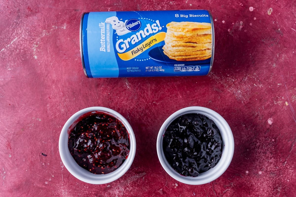 biscuits and two jams sitting on a table