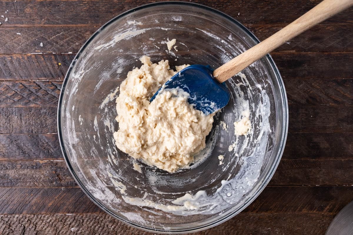 cobbler batter in a glass bowl with a spatula