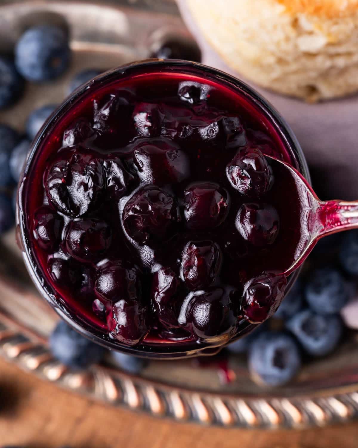 blueberry sauce in a jar with a spoon