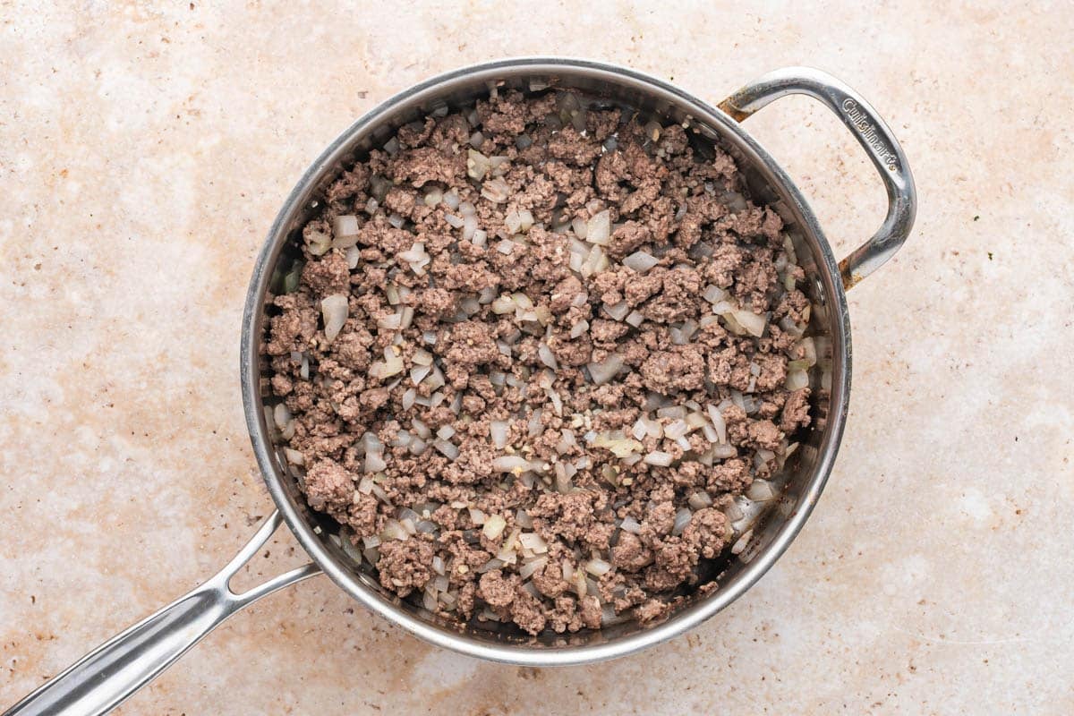 a skillet with ground beef and onions