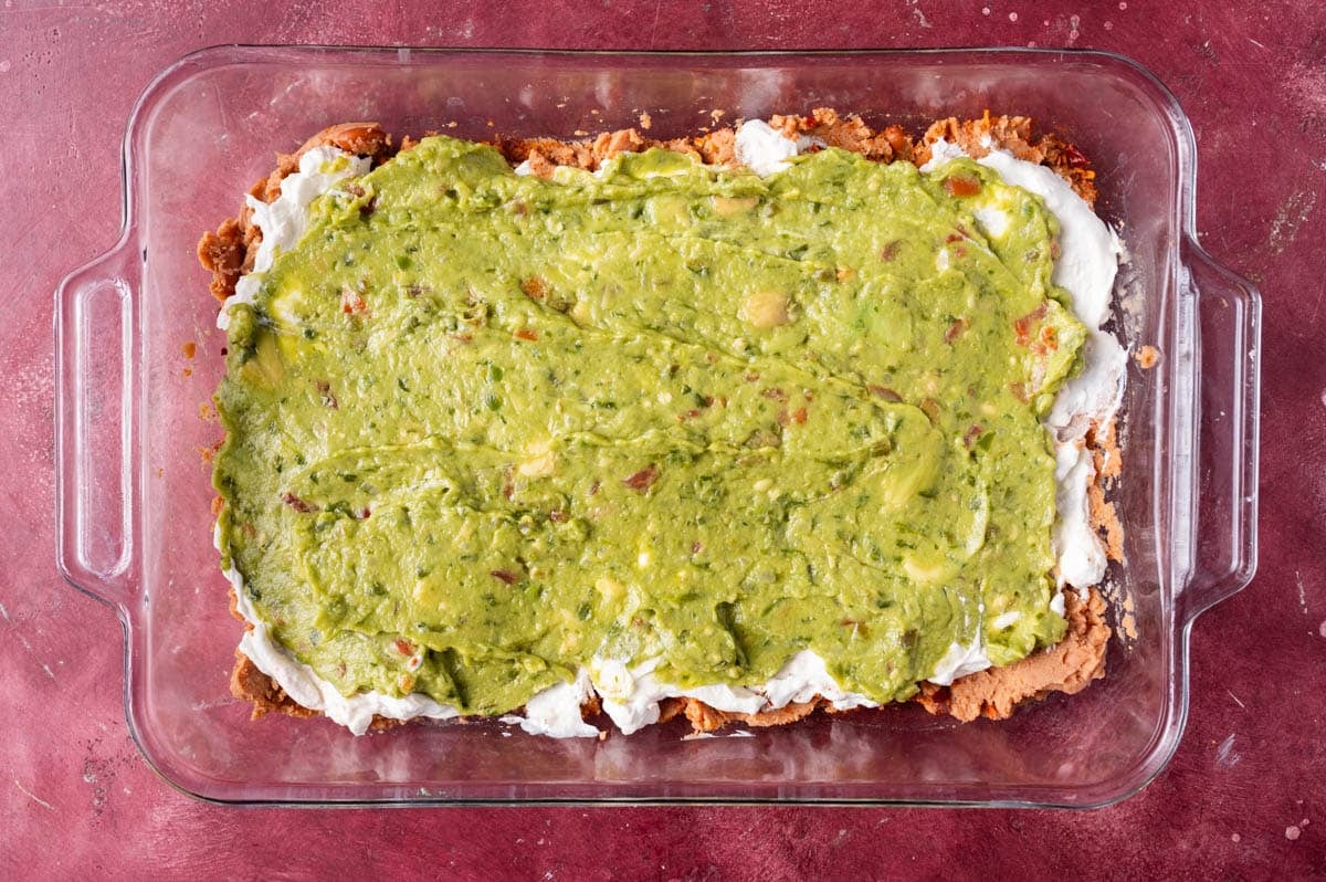 refried beans with sour cream and guacamole on top