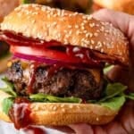 a hand holding a burger