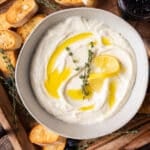 whipped ricotta in a bowl on the table with toast