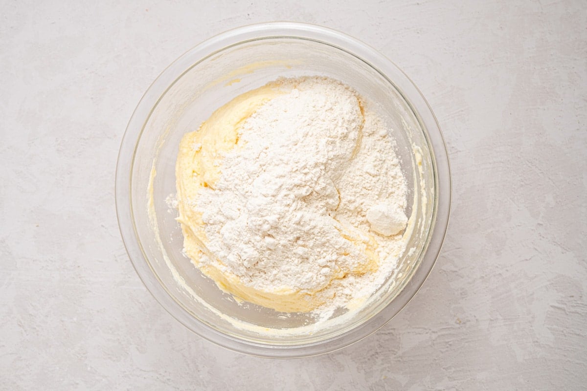 flour over cake batter in a bowl