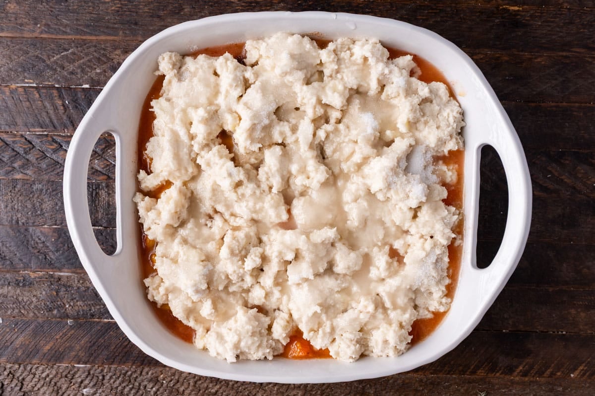 unbaked peach cobbler in a pan