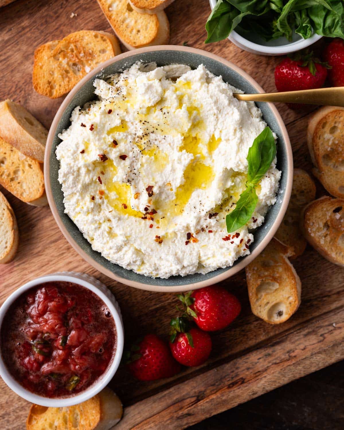 whipped feta in a bowl with crostini and strawberry jam