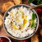 whipped feta in a bowl with crostini and strawberry jam