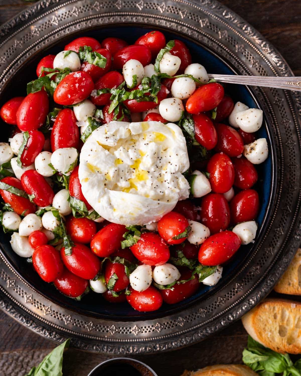a bowl of caprese salad with burrata on top