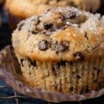 a chocolate chip muffin sitting on a table with coarse sugar on top