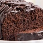 a chocolate olive oil loaf cake on a table with one slice cut