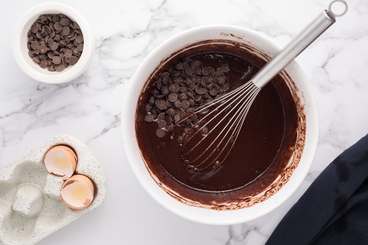 chocolate chips over chocolate batter in a bowl