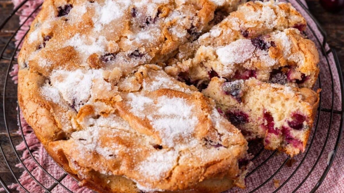 fresh cherry cake with sugar crunch top cut in slices on a table