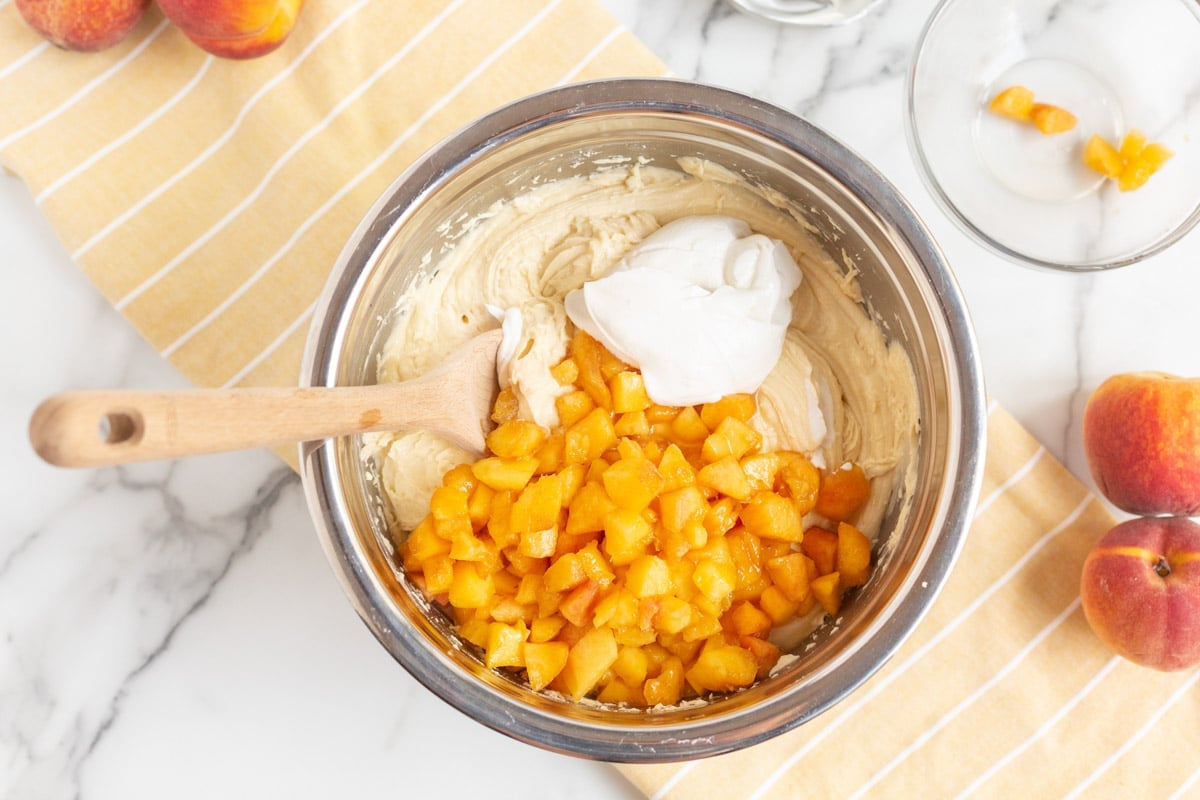 peaches and sour cream over batter in a bowl