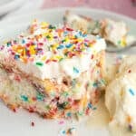 a piece of funfetti birthday cake on a plate with ice cream