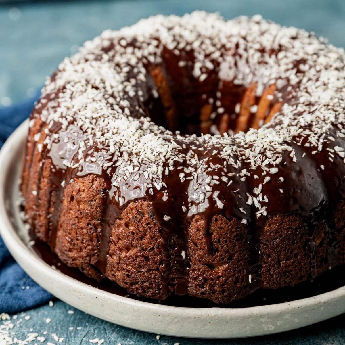 a chocolate bundt cake with coconut on an table