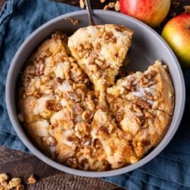 a slice of apple butterscotch cake on a spatula in a pan with a spatula