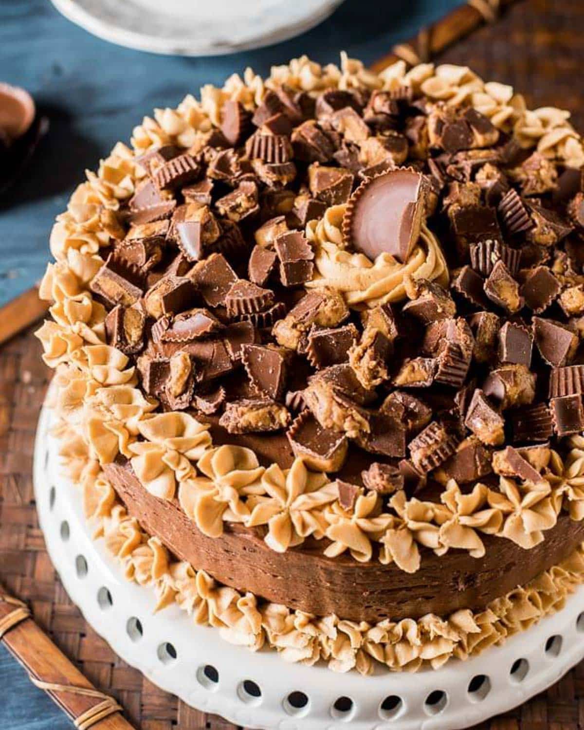 chocolate peanut butter cake with reese's cups on a cake plate